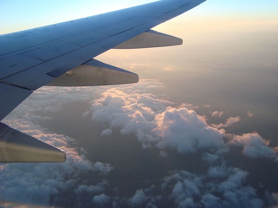 wing of an airplane from the window view with clouds on the background