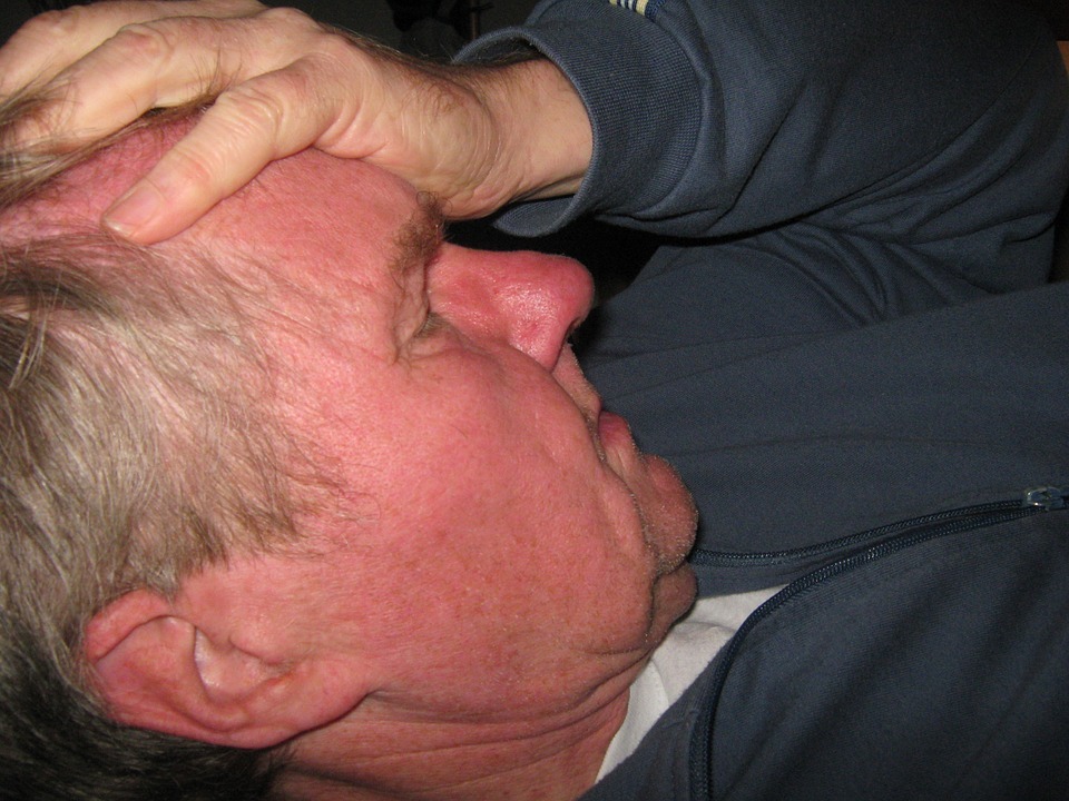 man with headache holding his forehead