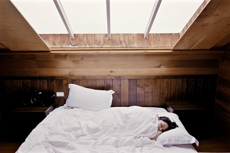 a woman sleeping in a comfy bed