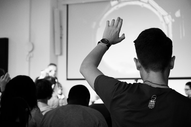 a student raising his hand to ask a question