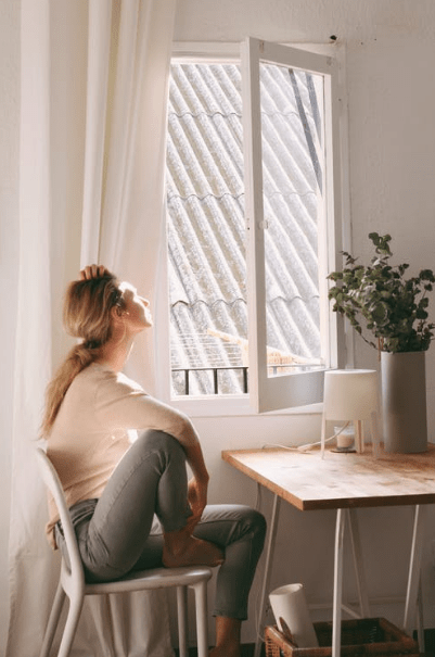 woman-sitting-on-a-chair-next-to-a-window