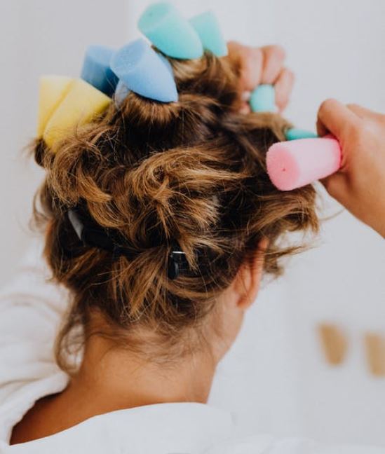 Woman putting curlers in her hair