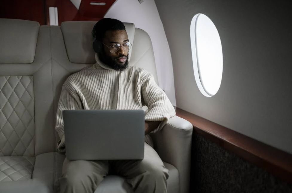 man-in-white-sweater-sitting-on-couch-using-macbook