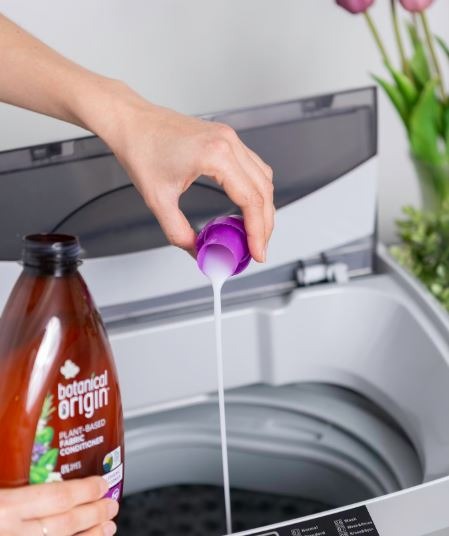 A person pouring detergent to the washing machine