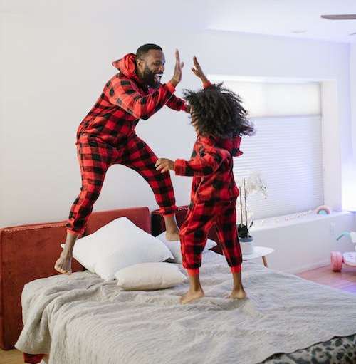 Father and Daughter Jumping on Bed
